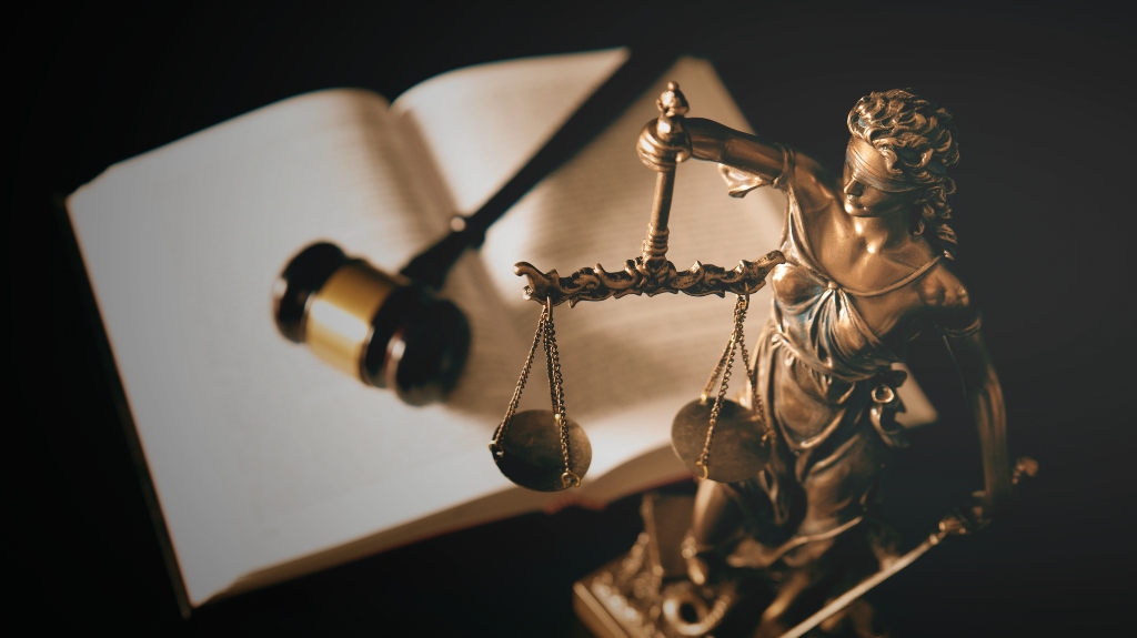 Lady Justice statue in law and books in background